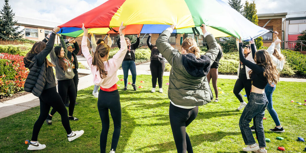 Childcare students using a parachute