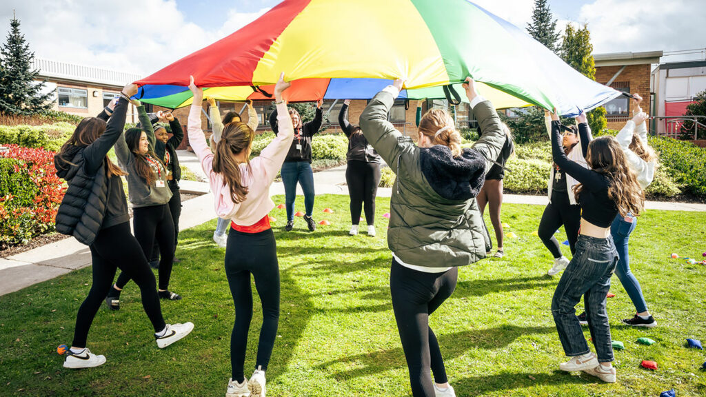 Childcare students using a parachute