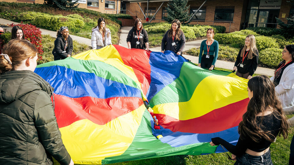 Childcare students using a parachute