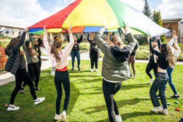 Childcare students playing parachute games