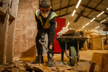 A plastering student digging