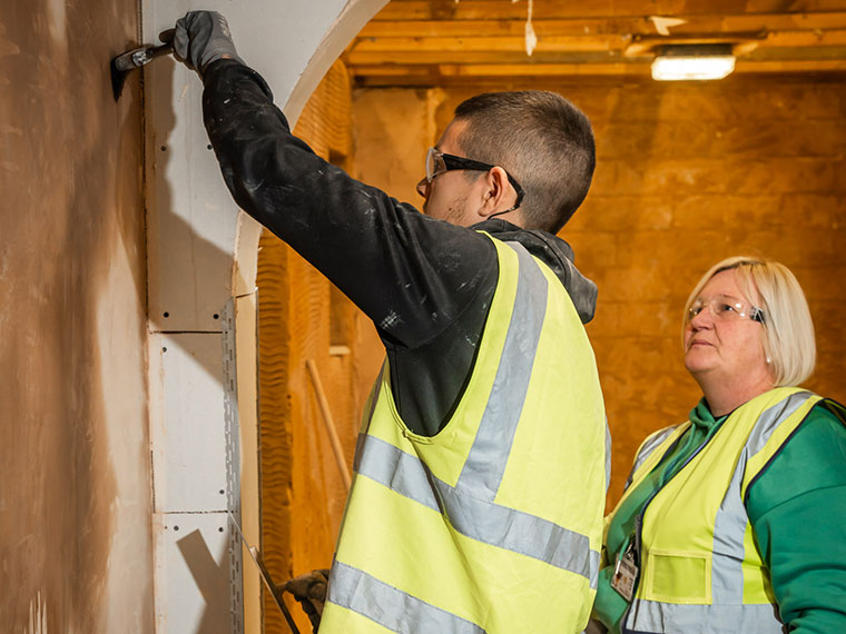 A plastering student with their lecturer