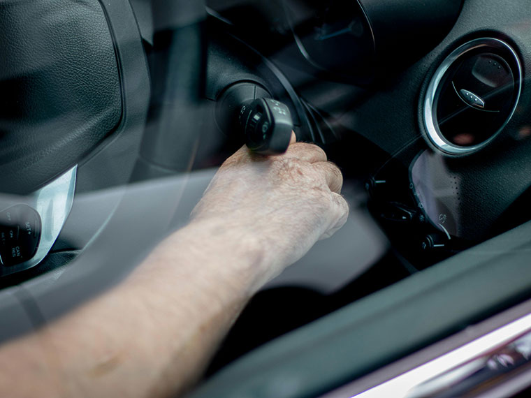 A close up of someone putting the key into a car ignition